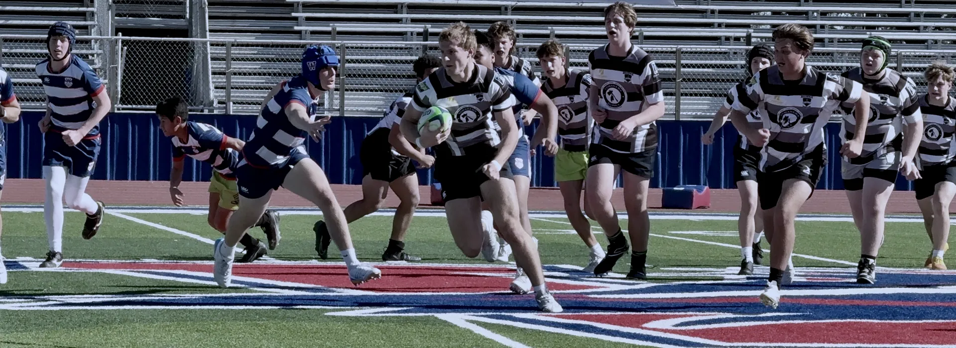 A Black Knights ball carrier runs through the defense with teammates in support